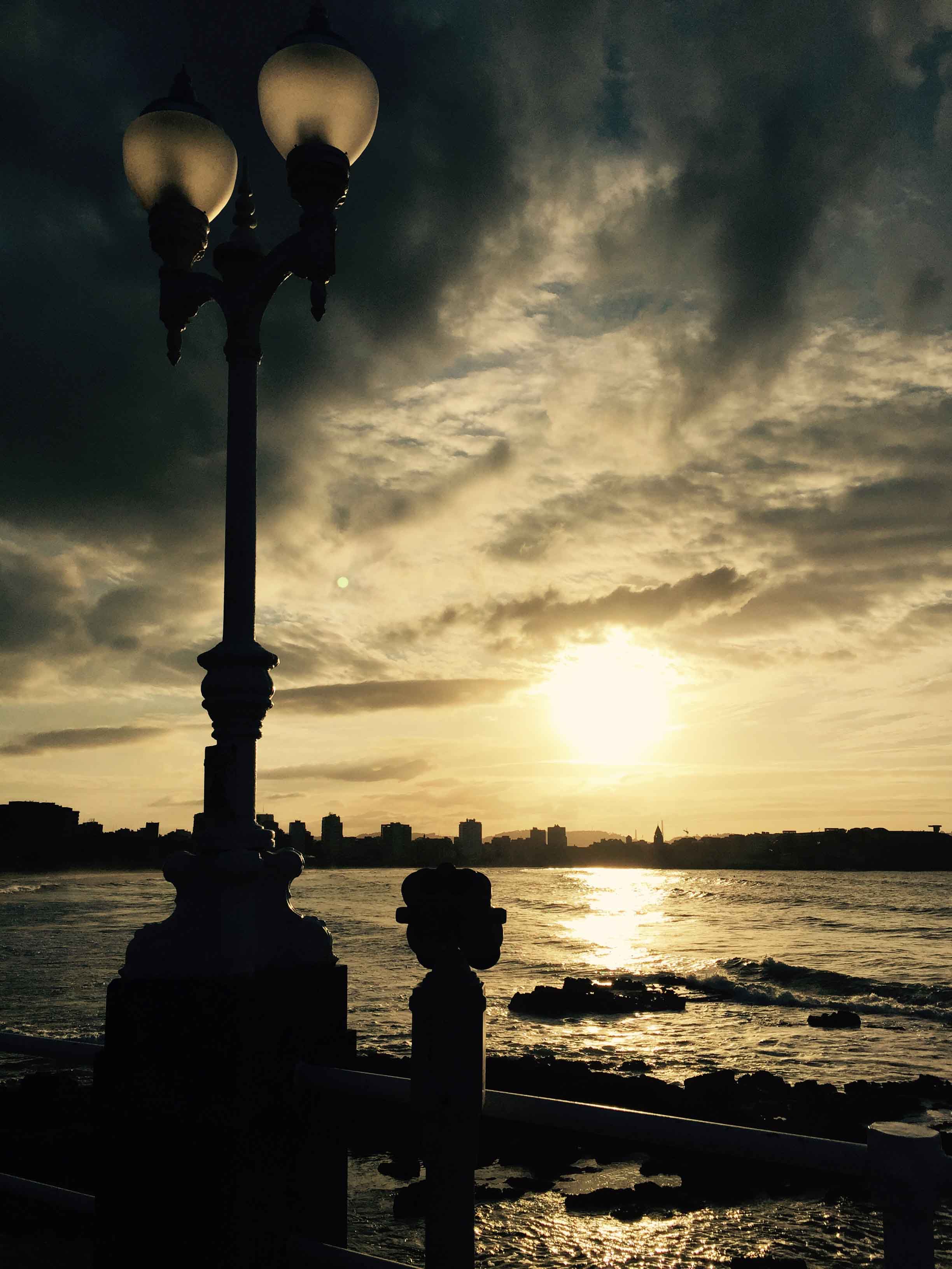 atardecer, farola del modelo gijon en la playa de san lorenzo