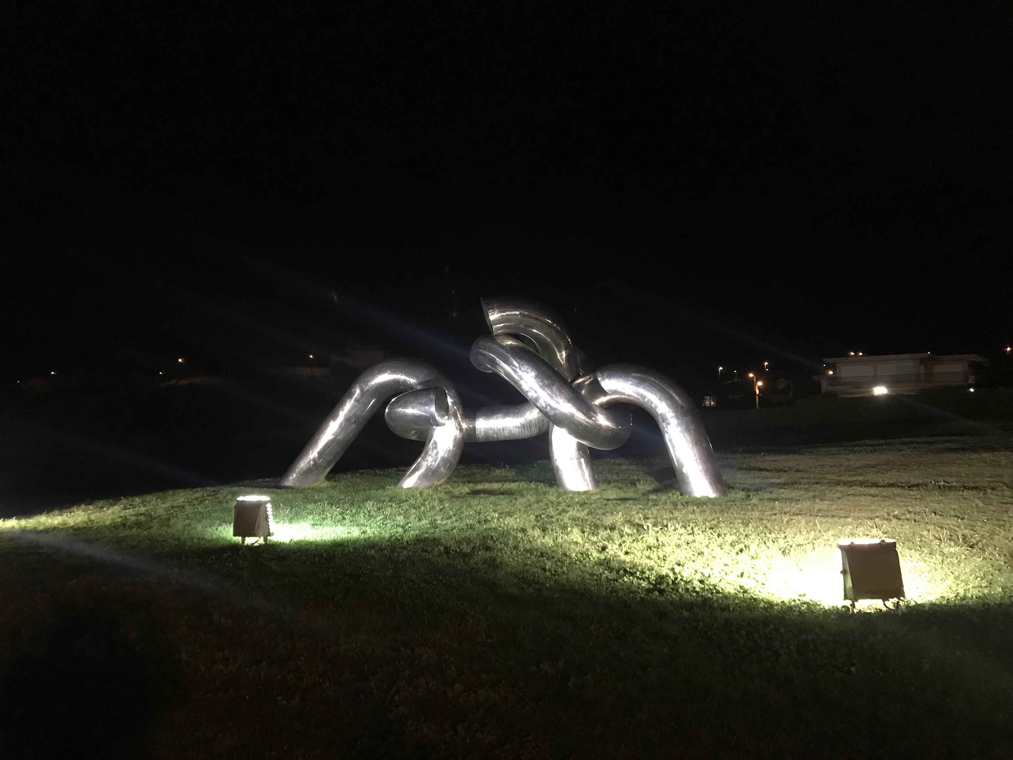 solidaridad escultura ilumanada al final de la playa de gijon