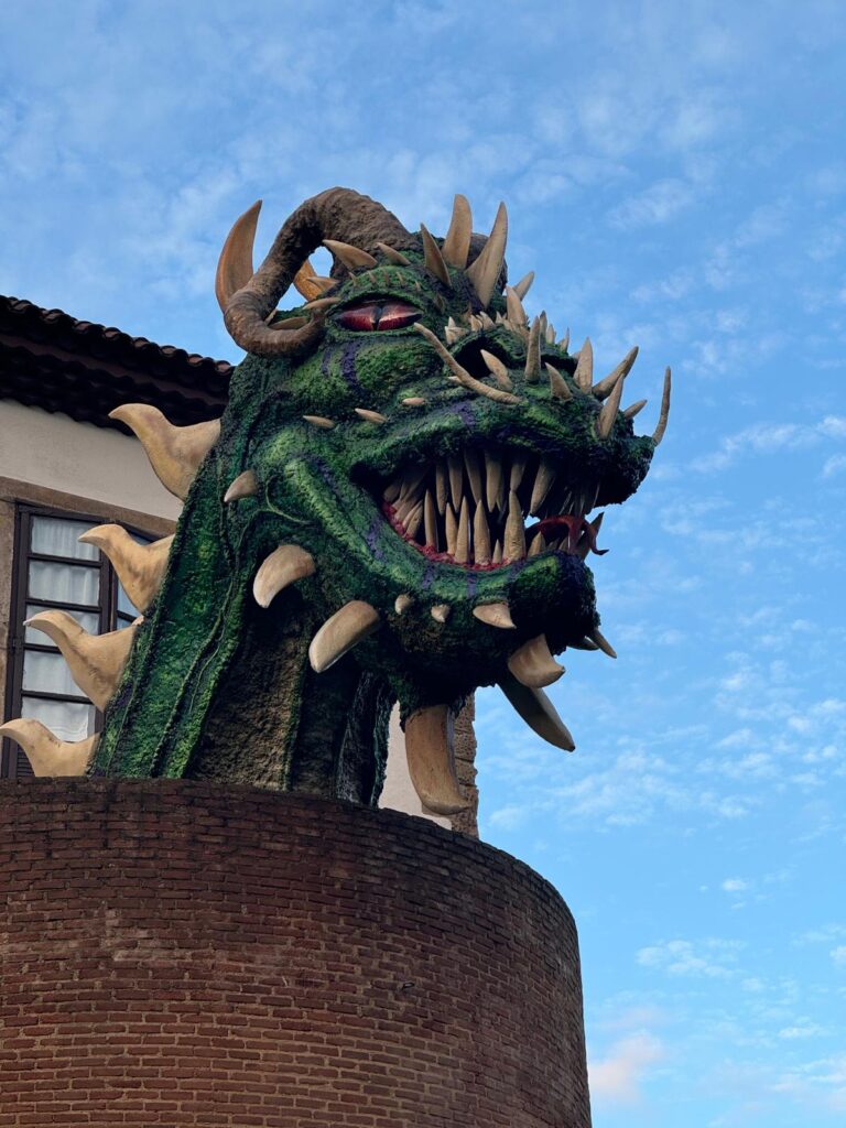 dragón de cimavila asomando sobre la muralla de la ciudad